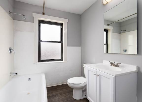A white bathroom with a toilet, sink, and bathtub.