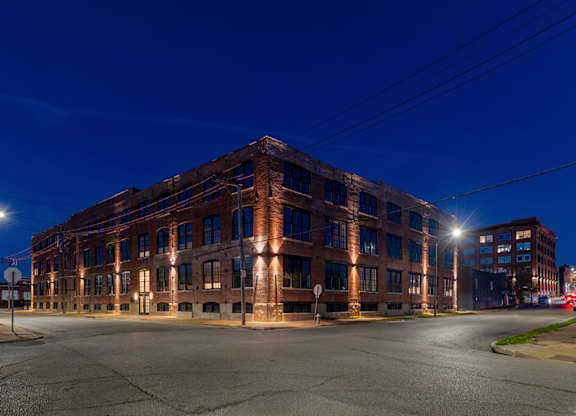 A large red brick building with a parking lot in front of it.