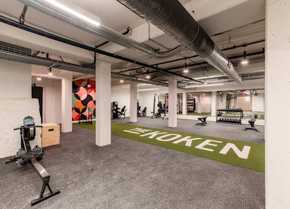 A gym with a green floor mat that says