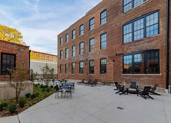 A courtyard with a table and chairs surrounded by brick buildings.