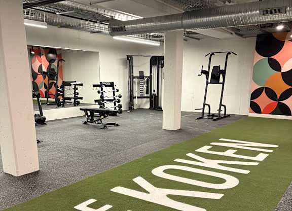 A gym with a green carpet that says