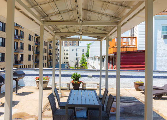 a patio with a wooden table and chairs and a pool at The Argonne Apartments, Washington, Washington DC