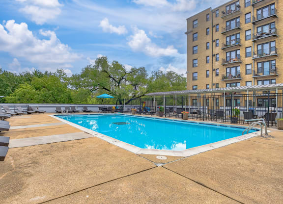 a swimming pool at a hotel with chairs and a building at The Argonne Apartments, Washington, DC