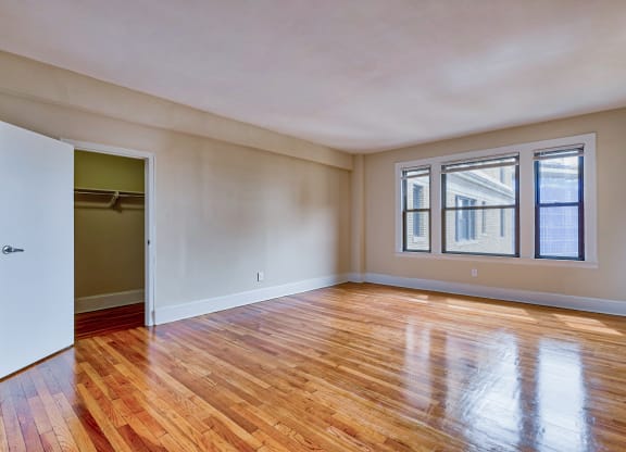 an empty living room with wood floors and a door at The Argonne Apartments, Washington, DC, 20009