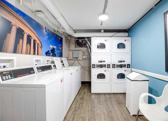 A row of washing machines are lined up in a room.