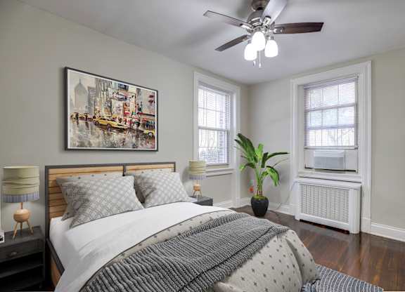 A bedroom with a large bed and a ceiling fan.