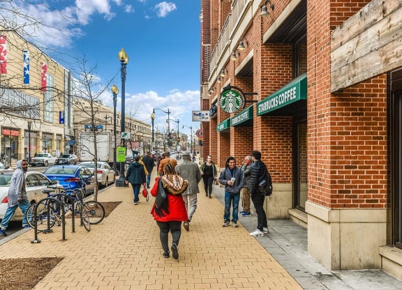 people walking down a city street in front of a brick building at The Argonne Apartments, Washington, Washington DC