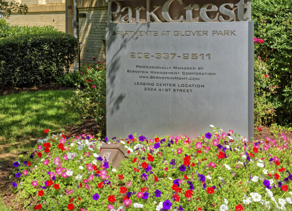 a sign in front of a building with flowers at Park Crest Apartments, Washington, DC