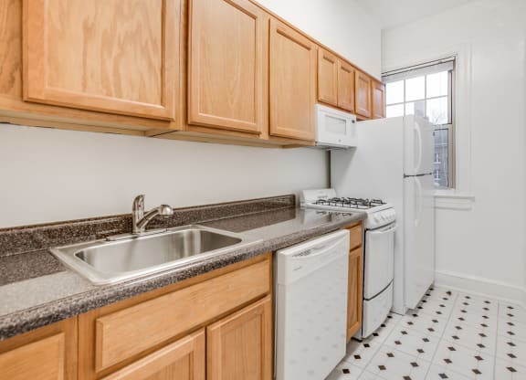 a kitchen with white appliances and wooden cabinets