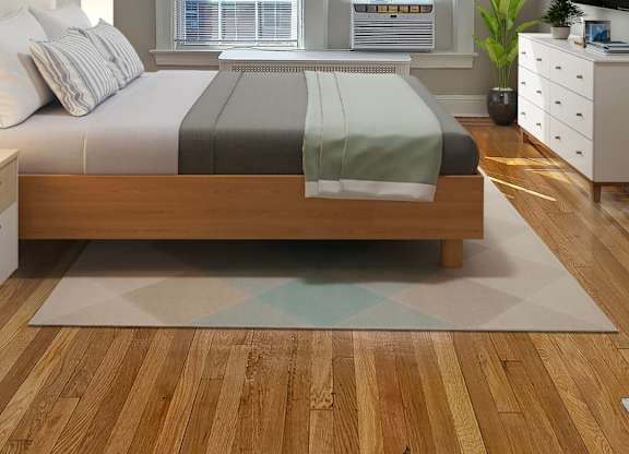 A bedroom with a bed, a dresser, and a window.