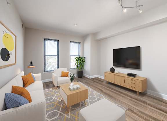 A living room with a white couch, a wooden coffee table, and a flat screen TV mounted on the wall.