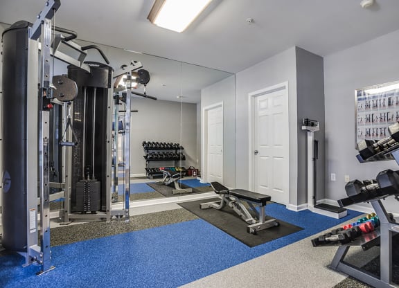 a home gym with a large mirror and exercise equipment at The Residences at King Farm, Rockville, Maryland