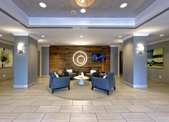 a lobby with couches and chairs and a flat screen tv
