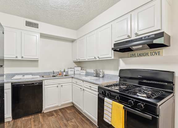 A kitchen with white cabinets and a black stove top oven.