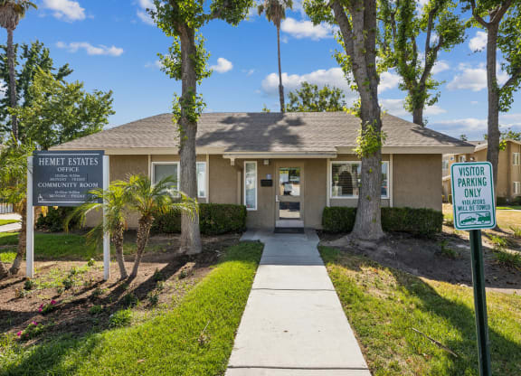 a house with a sidewalk and trees in front of it
