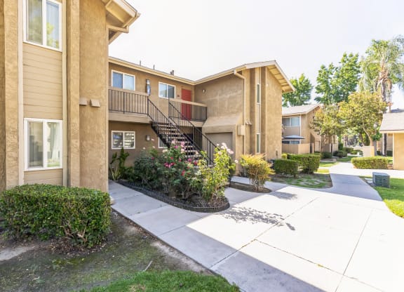 the outlook of an apartment building with stairs and a sidewalk