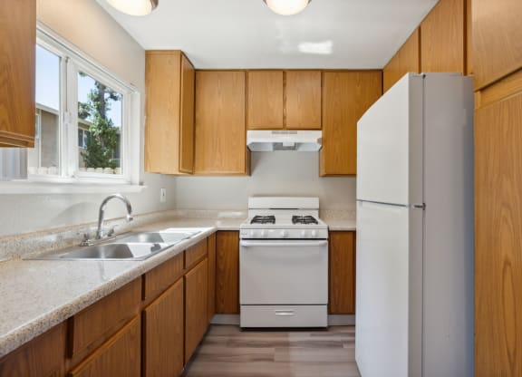 a kitchen with white appliances and wooden cabinets