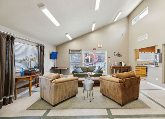 a living room with couches and a coffee table in front of a window