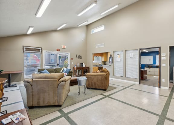 a living room with couches and chairs and a kitchen