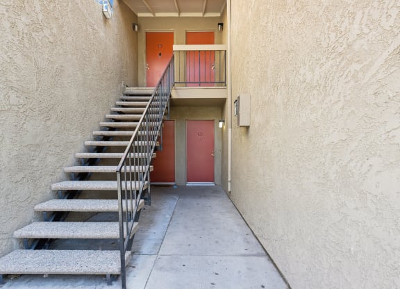 a set of stairs leading up to a building with a red door