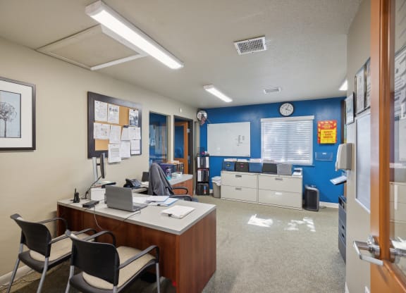an office with a desk and chairs and a clock on the wall