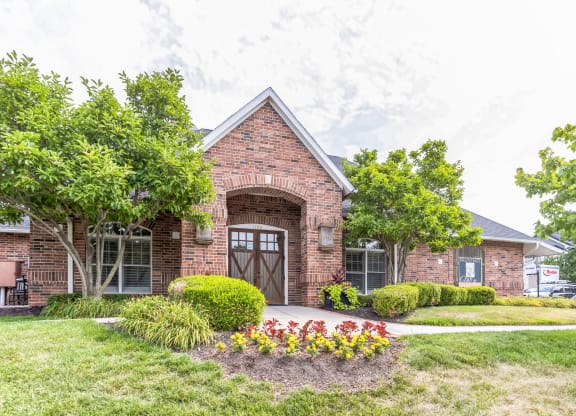 the front of a brick house with a driveway and a garage door
