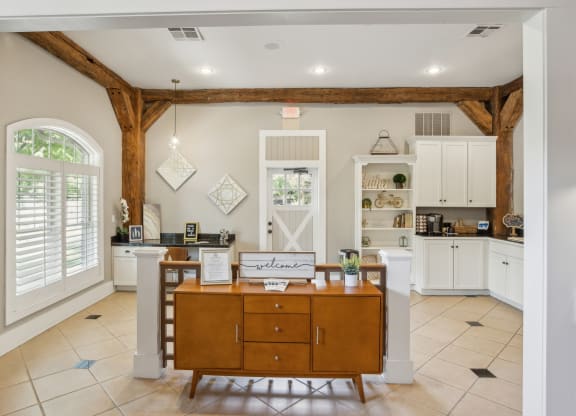 a kitchen with white cabinets and a wooden island with a wooden desk