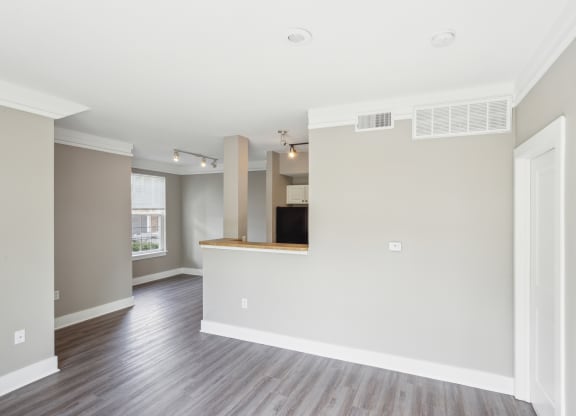 the living room and kitchen in a new home with wood floors and white walls