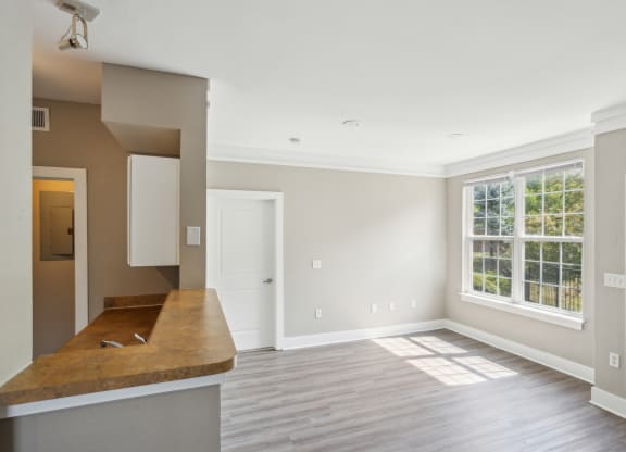 an empty kitchen and living room with a large window