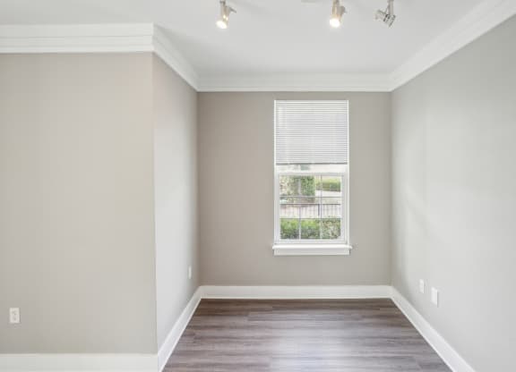 an empty room with wood floors and a window