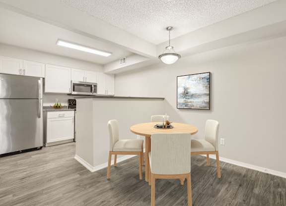 A kitchen with a table and chairs in the middle of the room.