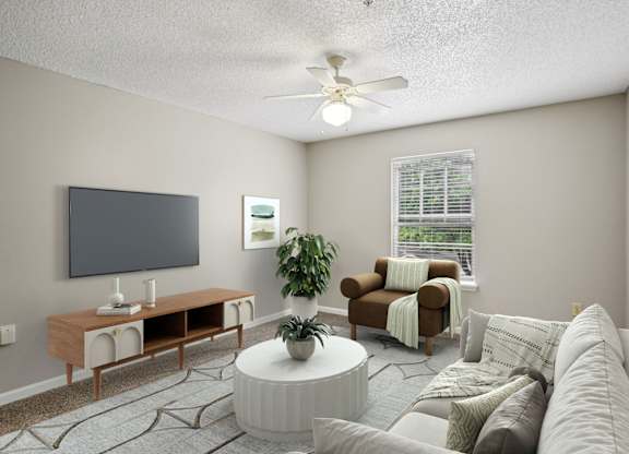 A living room with a white couch, a wooden entertainment center, and a ceiling fan.