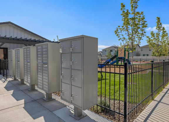A row of grey electrical boxes are lined up on a sidewalk.