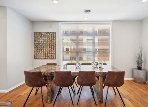 a dining room with a table and chairs and a window