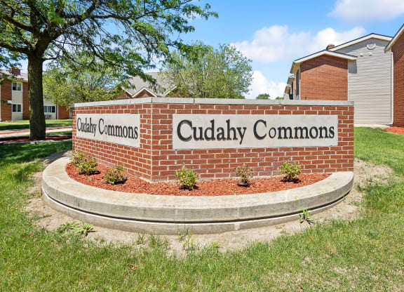 a brick monument sign for cuddly commons in front of a building