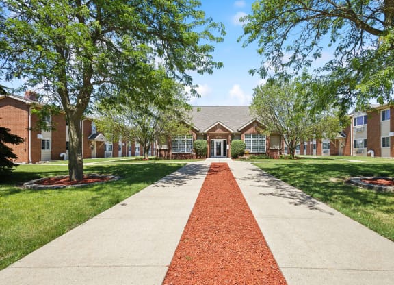 a sidewalk in front of a building with trees