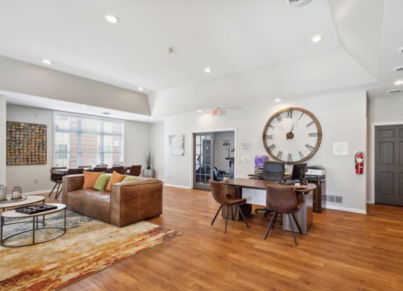 a living room with a large clock on the wall and a dining room table