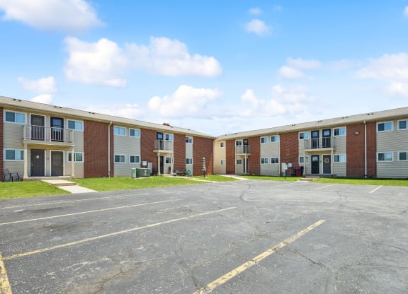 an empty parking lot in front of an apartment building