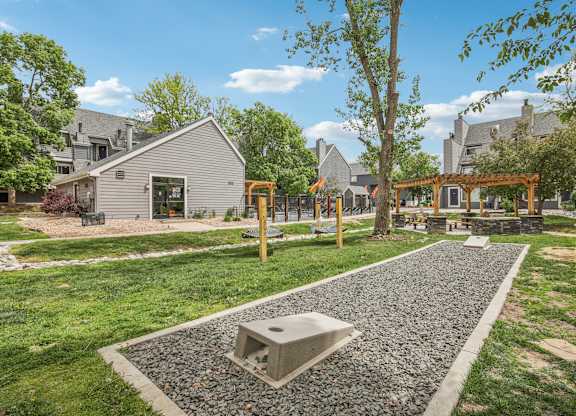 A playground with a slide and a swing set in a grassy area.