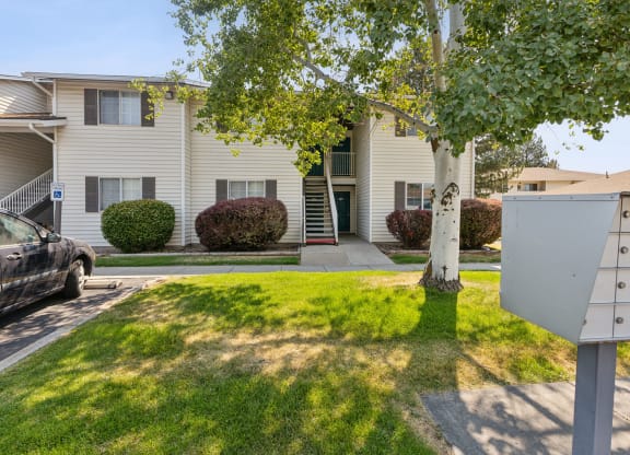 a white house with a yard and a mailbox in front of it