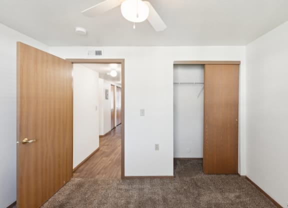 a bedroom with a closet and a door to a hallway