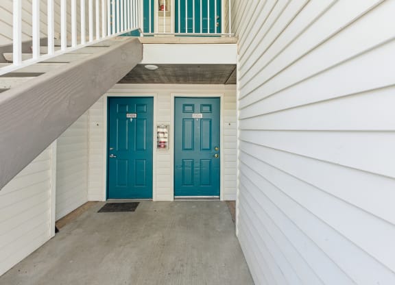 two blue doors on either side of a white house