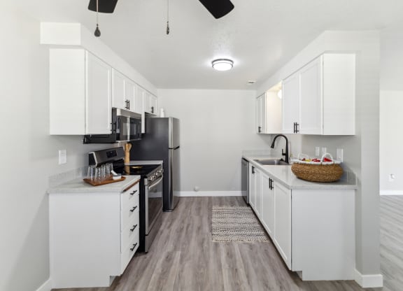 a kitchen with white cabinets and a stainless steel refrigerator
