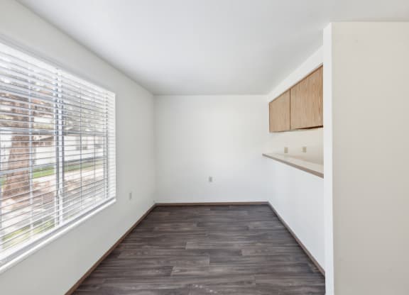 an empty living room with a large window and wood flooring
