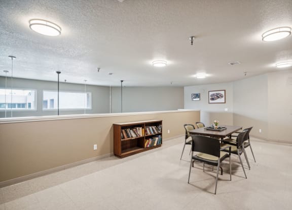 a dining room with a table and chairs and a bookshelf