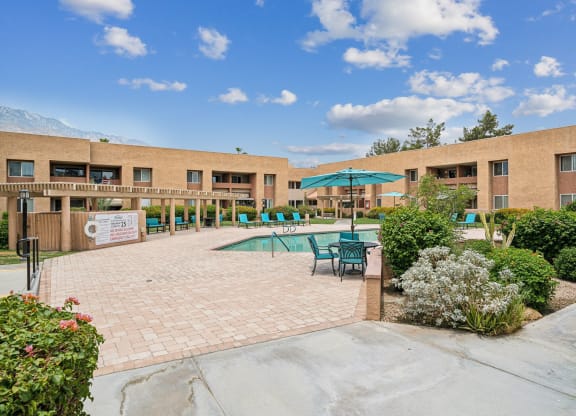our apartments have a large patio with tables and chairs and a pool