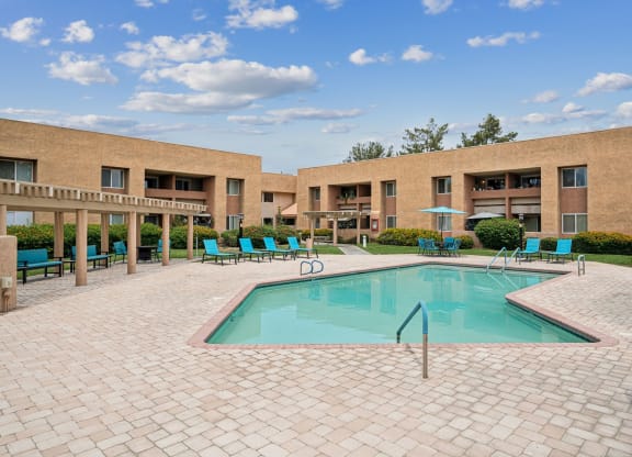 a swimming pool in front of an apartment building with a pool