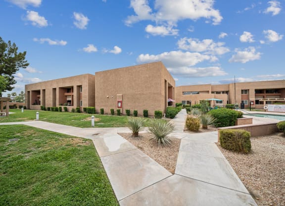 the exterior of a building with grass and a sidewalk