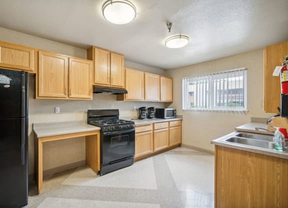 a kitchen with wood cabinets and black appliances and a sink