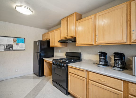 a kitchen with wood cabinets and a black stove and refrigerator